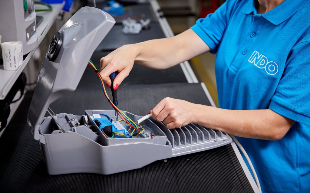 An INDO team member wiring the gear compartment of a street light on our Southampton production line