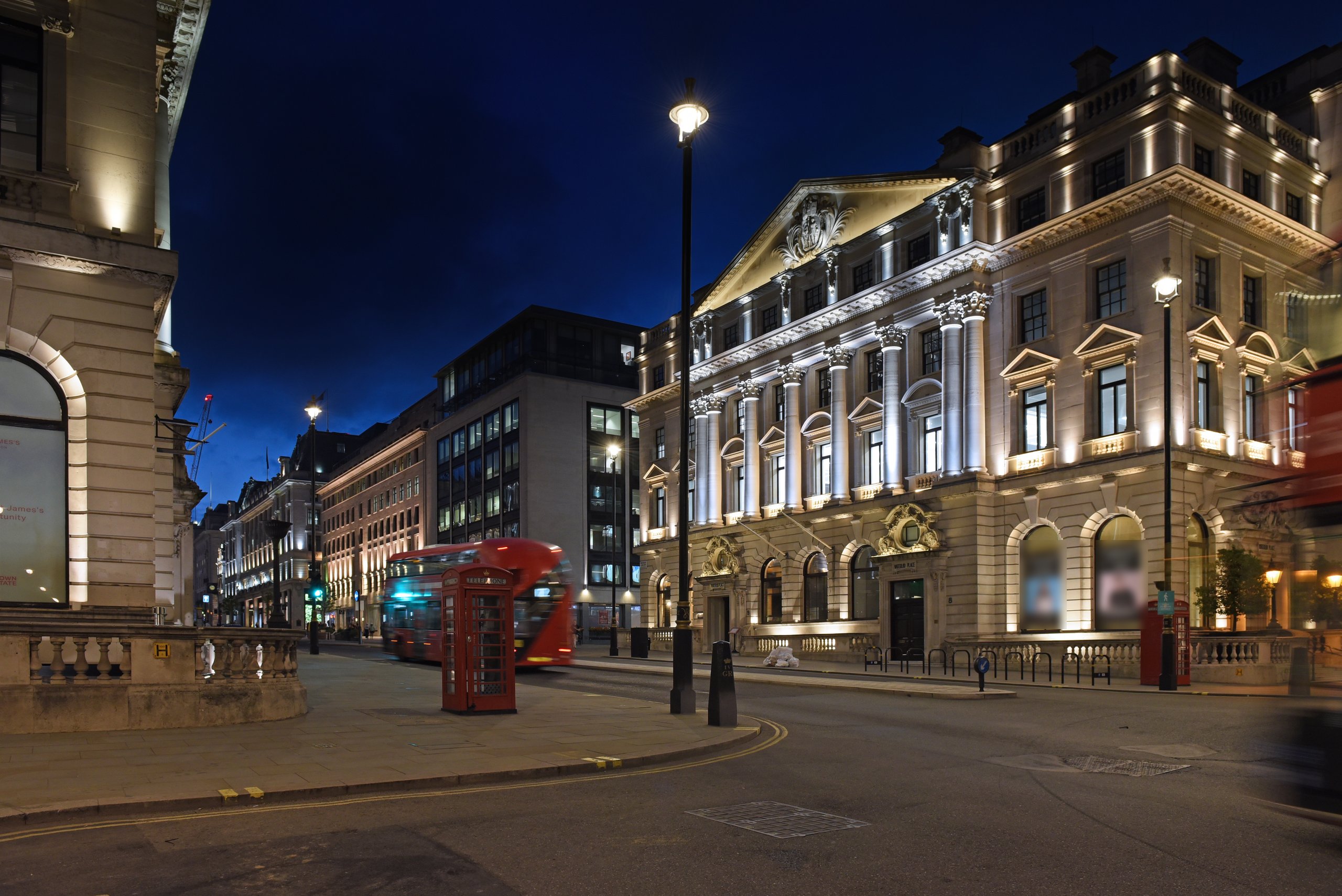 Heritage street lanterns on a Westminster street corner at blue hour, with a red telephone box