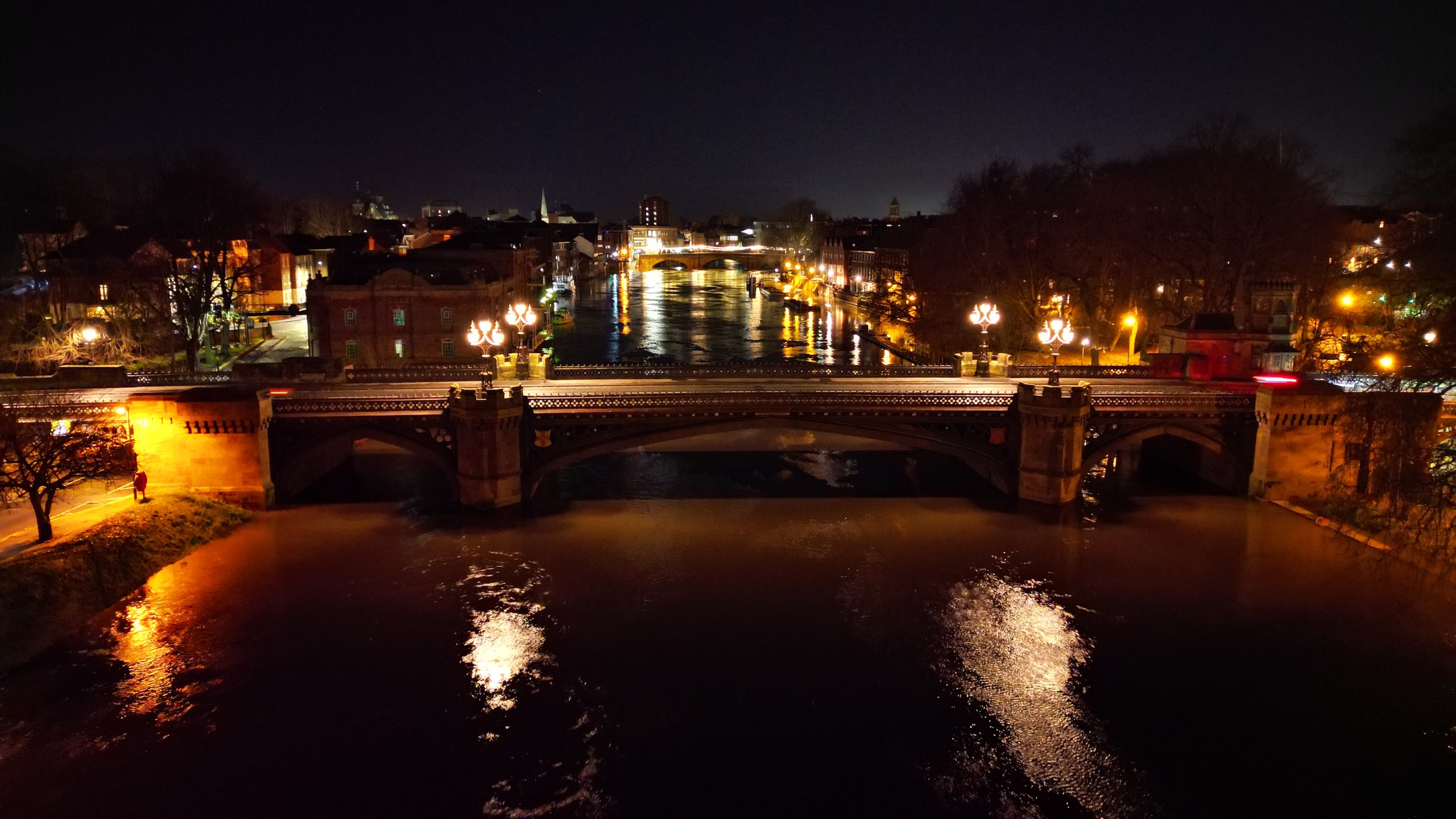A York bridge over the River Ouse at night with its heritage lanterns lit